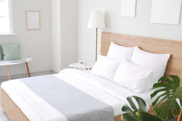 Bright and modern hotel room with a cozy bed, white linens, and minimalist décor.