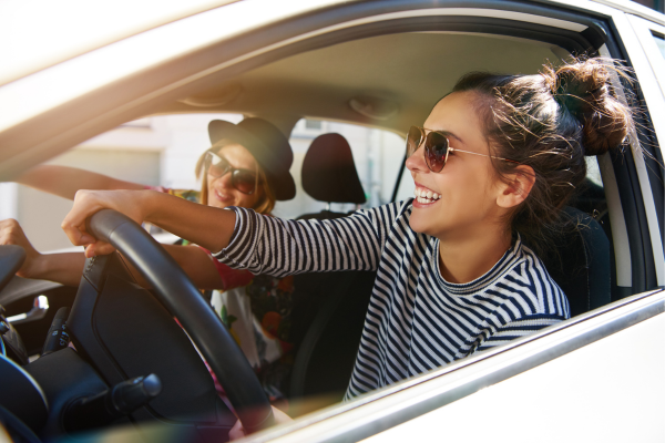 Two-friends-laughing-and-enjoying-a-sunny-drive-capturing-a-fun-road-trip-moment