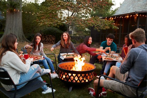 Friends-eating-a-pizza-around-fire-pit-